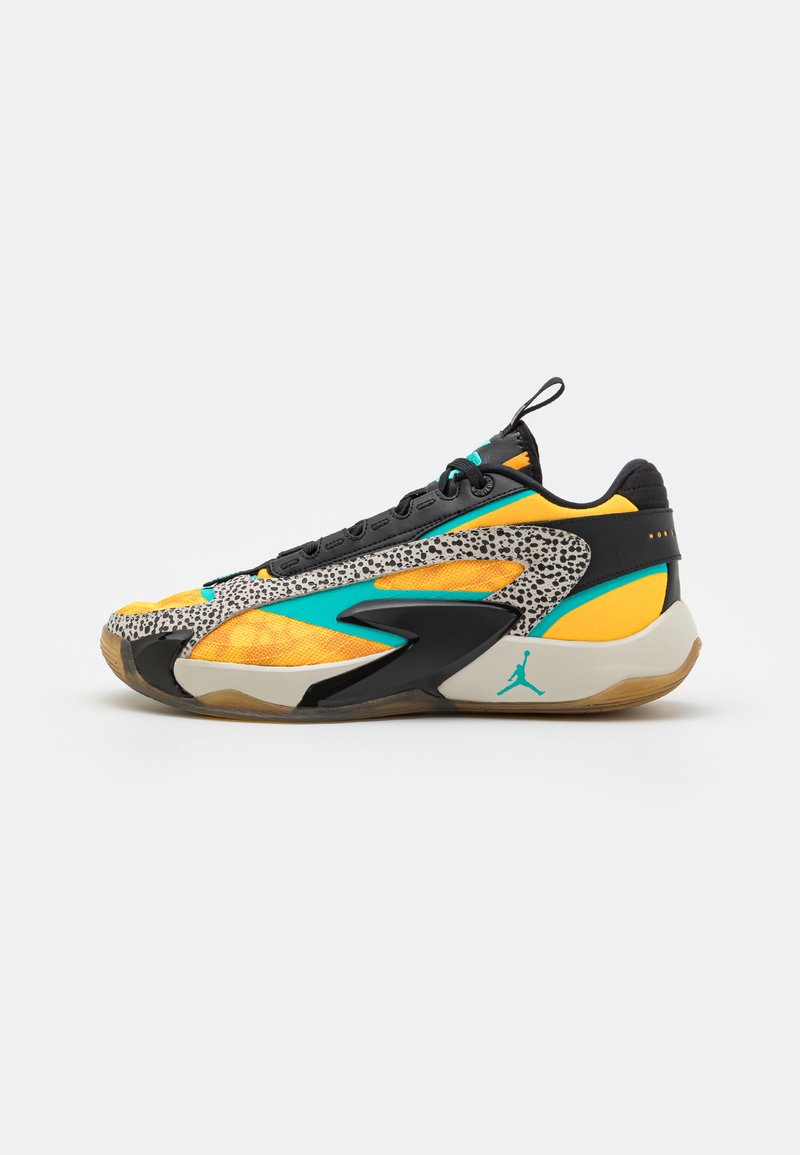 Des chaussures de basket-ball avec une tige en maille jaune et noire, des accents turquoise et un revêtement à motifs. Comprend une semelle en caoutchouc avec un logo visible.