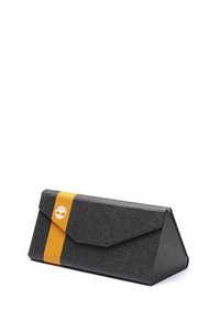 Cutie gri în formă triangulară, cu o bandă de accent galbenă. Fabricată din material texturat, are un sistem de închidere cu clapetă pliată și un logo pe bandă.