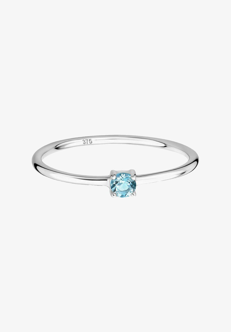 Silver ring featuring a round, light blue gemstone set in a simple four-prong setting on a smooth, narrow band.