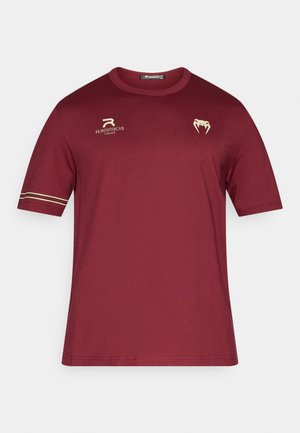 Bordeauxfarbenes kurzärmeliges T-Shirt aus Jersey-Stoff. Mit goldenen Akzenten, einem Logo auf der Brust und Streifen an den Ärmeln. Rundhalsausschnitt.