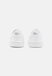 Vita lädersneakers med en slät textur, med en grå broderad logotyp på hälen, rund tå och platt gummisula.