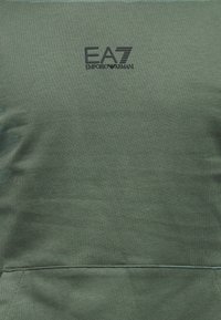 Zielona bawełniana bluza z kieszenią z przodu i haftowanym czarnym logo EA7, charakteryzująca się gładką teksturą i prostym designem.