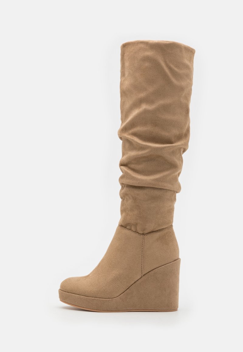 Botte à talon compensé haut avec un dessus en daim flou couleur brun caramel, vue de profil sur fond blanc.