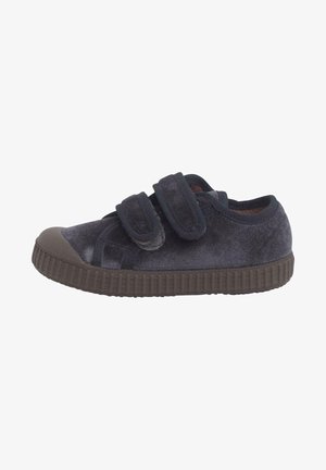Chaussures en velours bleu marine avec deux sangles Velcro ajustables, bout rond en caoutchouc et semelle texturée marron foncé. Doublure intérieure douce.