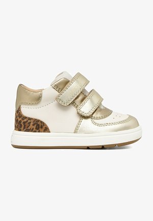 Scarpa da ginnastica bianca per bambini con cinturini e dettagli dorati, toppa con stampa leopardata sul tallone e suola in gomma bianca.