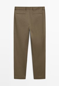 Bruna slim-fit byxor med bältesömmar och två bakfickor, uppvisade liggande från baksidan på en vit bakgrund.