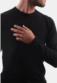 Maglione nero a maniche lunghe con scollo a girocollo rigato e polsini aderenti. Tessuto liscio, design dritto e senza motivi o elementi in vista.