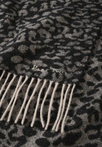 Wool scarf featuring a leopard print in black and gray, with beige fringes at one end. Subtle "Part Two" label is stitched near the fringe.