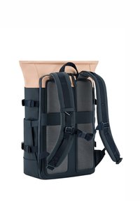 Batoh s rolovacím vrchem, tmavě námořnické tkaniny, síťovými panely, nastavitelnými popruhy a hladkým růžovým akcentem na vrchu.