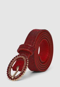 Cintura con strass rossi e una lucente fibbia ovale dorata, caratterizzata da una superficie testurizzata e una forma arrotolata per una vestibilità sicura.