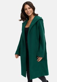 Green wool blend coat with an oversized hood, long sleeves, and an open front design. Features subtle branding on the sleeve.