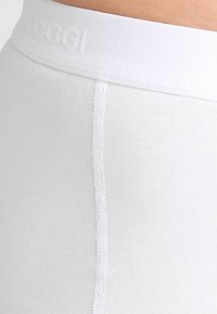Witte katoenmix strakke short met een gestructureerde tailleband, voorzien van reliëfbranding en flatlockstiksels langs de zijnaad.