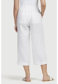 Weiße Leinen-Culottes mit elastischem Bund, cropped Länge und zwei hinteren Taschen. Glatte Textur und minimalistisches Design.