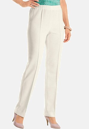 Witte geribde broek met een elastische tailleband die je aan kunt trekken en twee verticale naden aan de voorkant, gecombineerd met lichtroze hoge hakken.