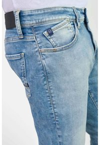 Lichtblauwe denim jeans met een slim fit, met een zwarte tailleband, voor- en achterzakken, en subtiele vervaging voor een versleten uiterlijk.