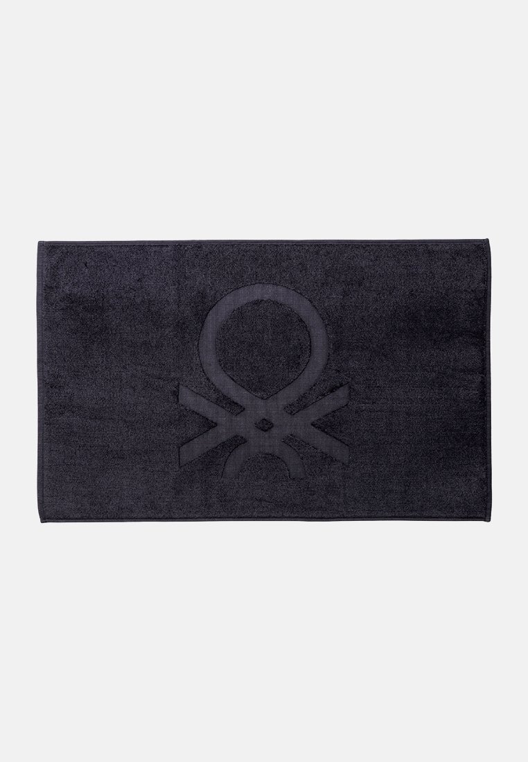 Czarny prostokątny ręcznik wykonany z puszystego materiału, z wyraźnym, wypukłym wzorem w centrum. Krawędzie są starannie wykończone.