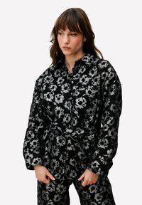 Zwart en zilver bloemmotief overhemd met een kraag en lange mouwen. Voorzien van een tailleband en een gestructureerde stof.