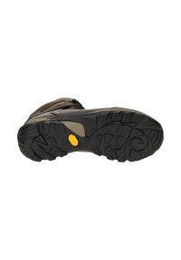 Chaussure de randonnée marron avec une semelle en caoutchouc texturée, un motif de bande de roulement défini et un logo Vibram jaune au dos, avec des accents en cuir sur le dessus.