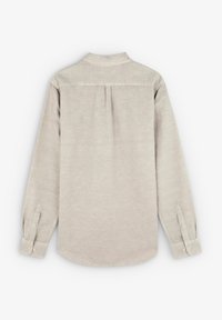 Cămașă cu mâneci lungi dintr-un material bej deschis, având un yoke pe spate, detalii cu pliuri și manșete cu nasturi. Textură netedă, design clasic al gulerului.