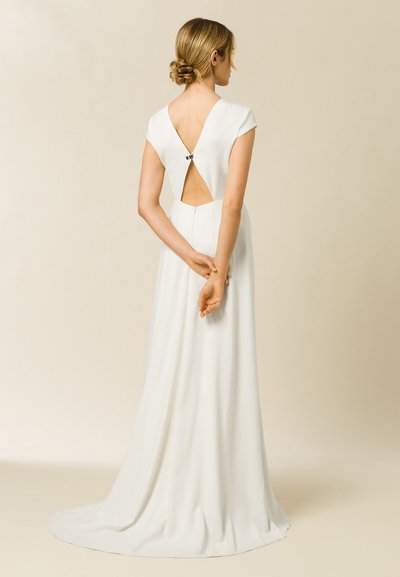 Robe longue blanche avec des manches courtes et un détail de dos nu, comportant un petit fermoir, un tissu fluide et une traîne. Texture lisse.