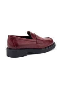 Mocassino in pelle borgogna con punta rotonda, dettagli cuciti e suola in gomma nera. Design minimalista con una texture liscia.