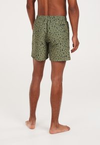 Męskie szorty kąpielowe w oliwkowym kolorze z czarnymi abstrakcyjnymi wzorami. Posiadają elastyczny pas oraz tylnią kieszeń. Wykonane z lekkiego materiału.