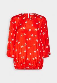 Blusa de satén roja con cuello redondo, mangas 3/4 y dobladillo fruncido. Presenta un estampado floral en blanco, rosa y amarillo. Cierre en la espalda con abertura tipo ojal.