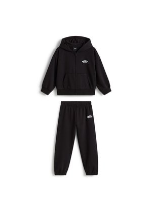 Felpa nera con cappuccio e zip e pantaloni della tuta abbinati con piccoli loghi bianchi Vans sul petto e sull'anca, esposti su sfondo bianco.