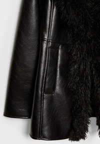 Čierna kožená bunda s textúrovanou umelou kožušinou vo vnútri, s bočnou kapsou a hladkým povrchom na koženom exteriéri.