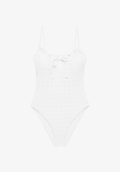 Λευκό ολόσωμο μαγιό με λεπτές τιράντες στους ώμους, σχέδιο με λουλουδάκια σε οπές, βολάν στο ντεκολτέ και μπροστινή δέση με άνοιγμα σε σχήμα κλειδαρότρυπας.