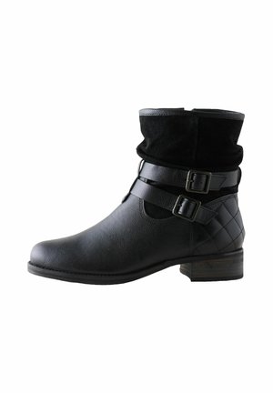 Botas negras hasta el tobillo con un acabado de cuero texturizado, que cuentan con una parte superior de gamuza negra doblada, dos correas decorativas con hebillas y un tacón bajo de madera.