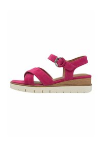 Sandalo in suede rosa con cinturini incrociati, una cintura alla caviglia con fibbia, tacco a zeppa in legno e suola piatta bianca. Presenta una texture liscia.