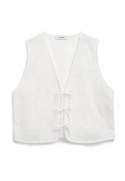 Débardeur blanc sans manches en tissu texturé avec un motif en quadrillage, doté de détails en œillets et d'une fermeture à lien sur le devant.