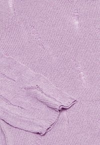 Țesătură tricotată de culoare violet, cu un model texturat; prezintă cusături vizibile și margini ușor desfăcute, oferind un aspect moale și ușor.