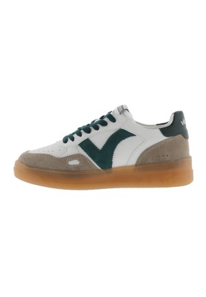Baskets avec une tige en cuir blanc, des accents en daim vert, un revêtement en daim beige et une semelle en caoutchouc translucide ambrée.