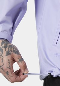 Light purple waterproof jacket with a smooth texture. Features an adjustable drawstring at the hem and a zippered pocket on the side.