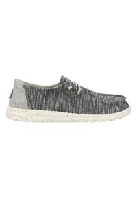 Zapato de tela tejido en gris y negro con punta redonda, suela de goma blanca con manchas y acentos de tela gris en el talón y la lengüeta.