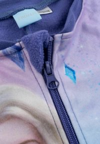 Giacca in pile con zip caratterizzata da colori pastello, un design ghiacciato e il logo di Disney Frozen. Texture morbida con accenti visivi di cristalli di ghiaccio.