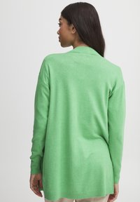 Cardigan léger à manches longues de couleur vert vif. Présente une coupe décontractée, des poignets côtes et un design de col classique. Texture lisse.