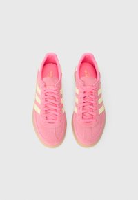 Ροζ σουέντ αθλητικά παπούτσια με μπεζ ρίγες, στρογγυλή μύτη, κλείσιμο με κορδόνια και εξωτερική σόλα από καουτσούκ τύπου gum. Υπόλοιπο με υφή και μαξιλαρωμένο κολάρο.