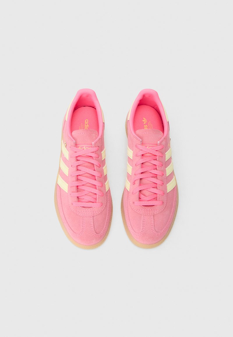 Rosa Wildledersneaker mit beigen Streifen, runder Kappe, Schnürverschluss und Gummilaufsohle. Strukturierte Oberseite mit gepolstertem Kragen.