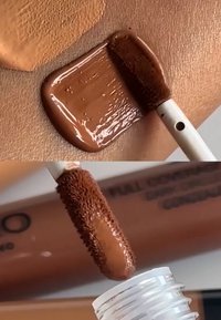 Cache-cernes couvrance totale en teinte marron sur la peau, applicateur avec pinceau doux, et tube de produit étiqueté "COUVRANCE TOTALE".