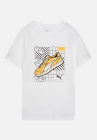 Vit bomullströja med en grafik av en gul Puma-sko med svarta konturer på en rutad bakgrund. Inkluderar "1948" i orange.