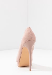 Růžová semišová lodička s špičatou špičkou a úzkým stiletto podpatkem, s hladkým, jemným povrchem a nahou podrážkou.
