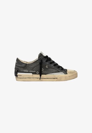 Sneaker nero basso con suola beige, dettagli usurati, lacci neri e marchio "Crime London" sul lato.