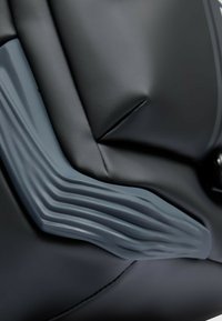 Material acolchado negro con un asa gris texturizado que presenta estrías. Enfoque en formas y ángulos, sin detalles ni adornos adicionales.