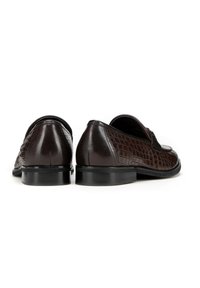 Bruine leren schoenen met een gestructureerd krokodillenpatroon, een ronde teenvorm en een lage hak. Zwarte buitenzool met een gladde afwerking.