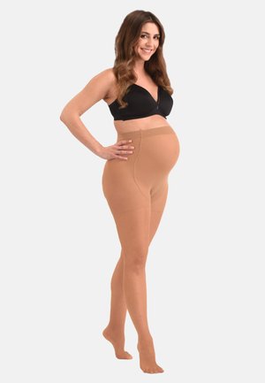 Medias de maternidad en color nude con una cinturilla cómoda, textura suave, cobertura completa y puntera reforzada, exhibidas en un modelo de pie.