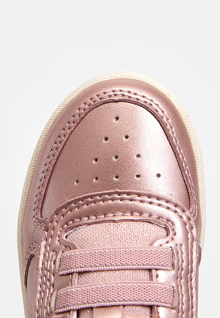 Sneakers métalliques rose avec un bout perforé, un laçage à l'avant, une semelle en caoutchouc crème contrastante et des détails cousus le long des bords.