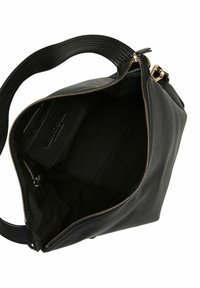 Bolso de cuero negro con apertura con cremallera, que presenta un exterior liso, una correa texturizada y un interior de tela negra. Etiqueta interior visible.